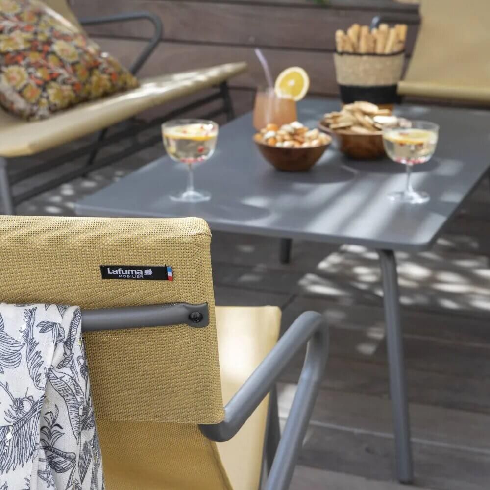 Fauteuil bas LAFUMA Jaune Safran en situation sur terrasse extérieure, mobilier CHR design et convivial.