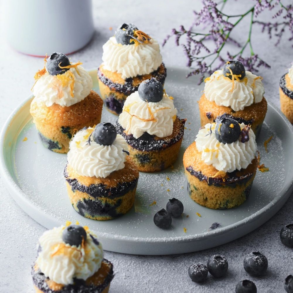 Mini-muffins à la vanille maison décorés de crème et myrtilles