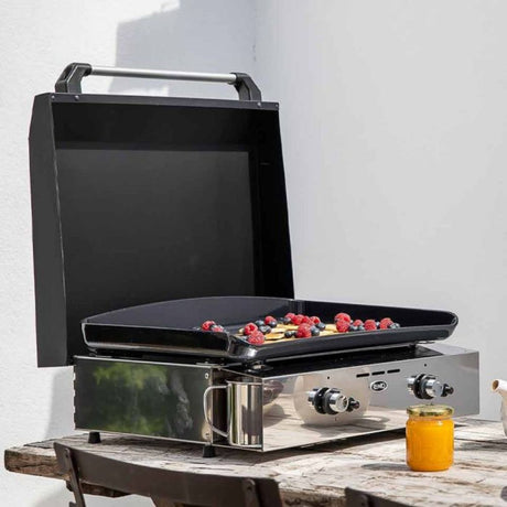 Plancha inox en extérieur avec couvercle ouvert et cuisson de pancakes aux fruits rouges.
