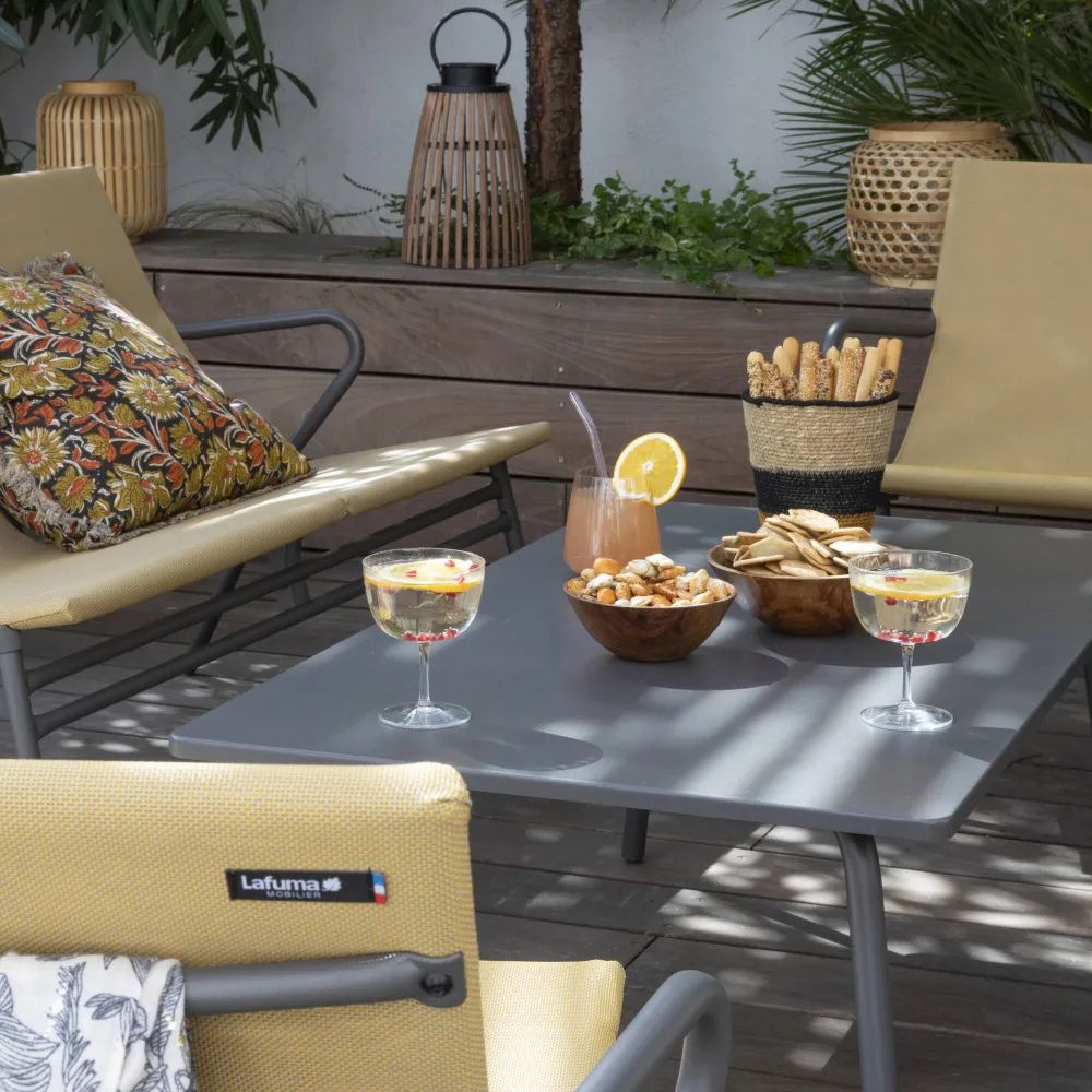 Table basse Vence rectangulaire LAFUMA sur terrasse aménagée avec mobilier CHR, plateau gris titane en acier, ambiance lounge extérieure.