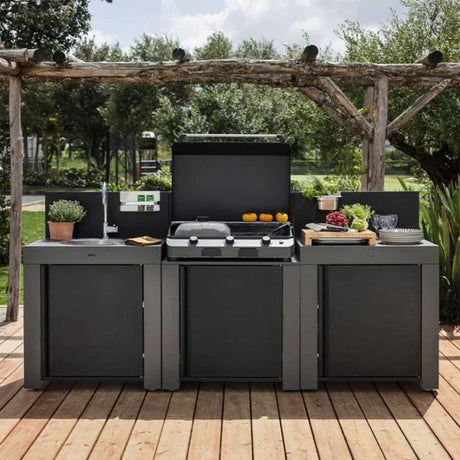 Cuisine d’extérieur design installée sur terrasse en bois, idéale pour cuisiner en plein air avec évier, plancha et rangements intégrés.
