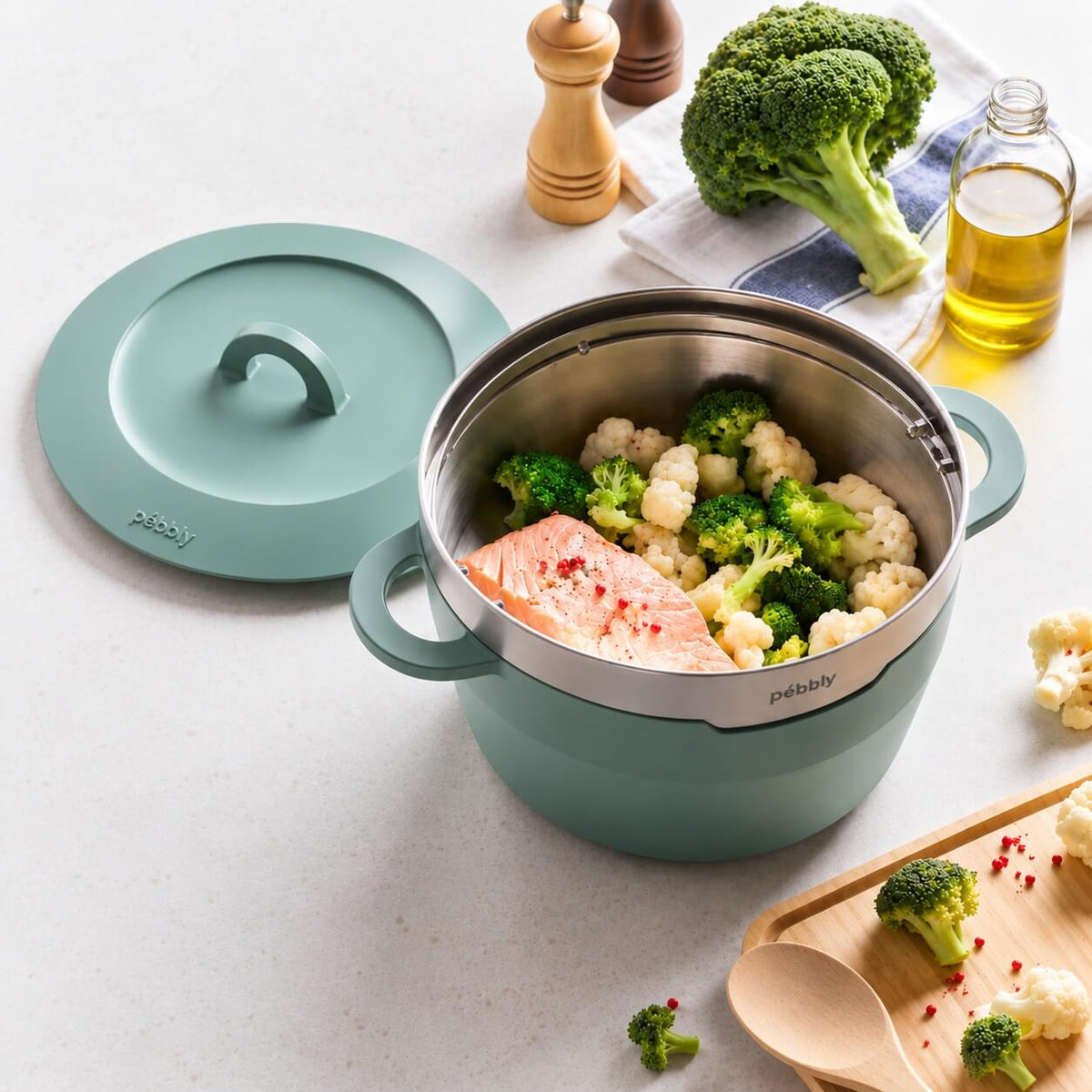 Cocotte céramique Pebbly 24 cm Mint Sage avec panier vapeur en situation de cuisson