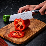 Couteau Santoku Signature 18 cm 32 DUMAS utilisé pour découper un poivron rouge