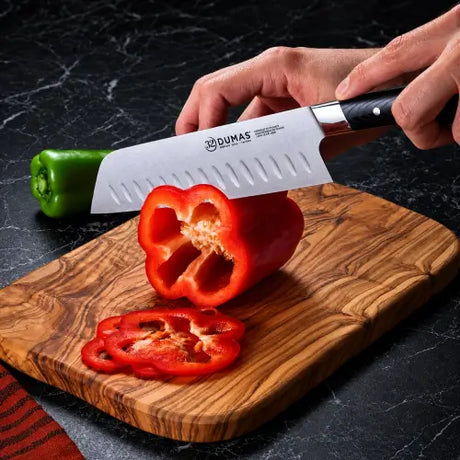 Couteau Santoku Signature 18 cm 32 DUMAS utilisé pour découper un poivron rouge