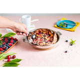 Poêle inox Mutine CRISTEL sur la table avec recette clafoutis
