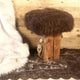 Coussin en Peau de Mouton Mérinos Marron sur Tabouret - Les Sculpteurs du Lac
